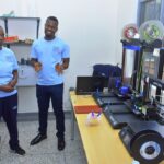 Joyce Nakibirango and Collins Olowo attending to the 3D printing machines at CoRSU rehabilitation hospital